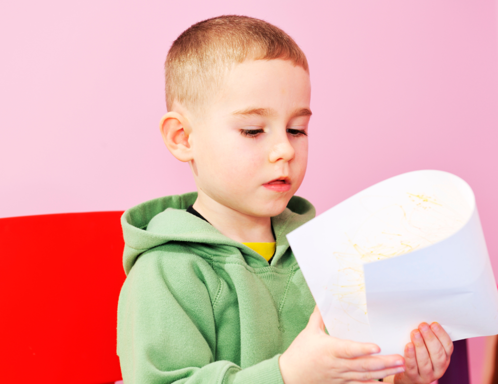 child folding paper in a symmetry activity for kids